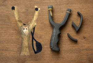 A handmade slingshot next to a broken plastic one.jpg