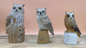 Set of three hand-carved wooden owl figurines in different sizes and natural wood finishes.