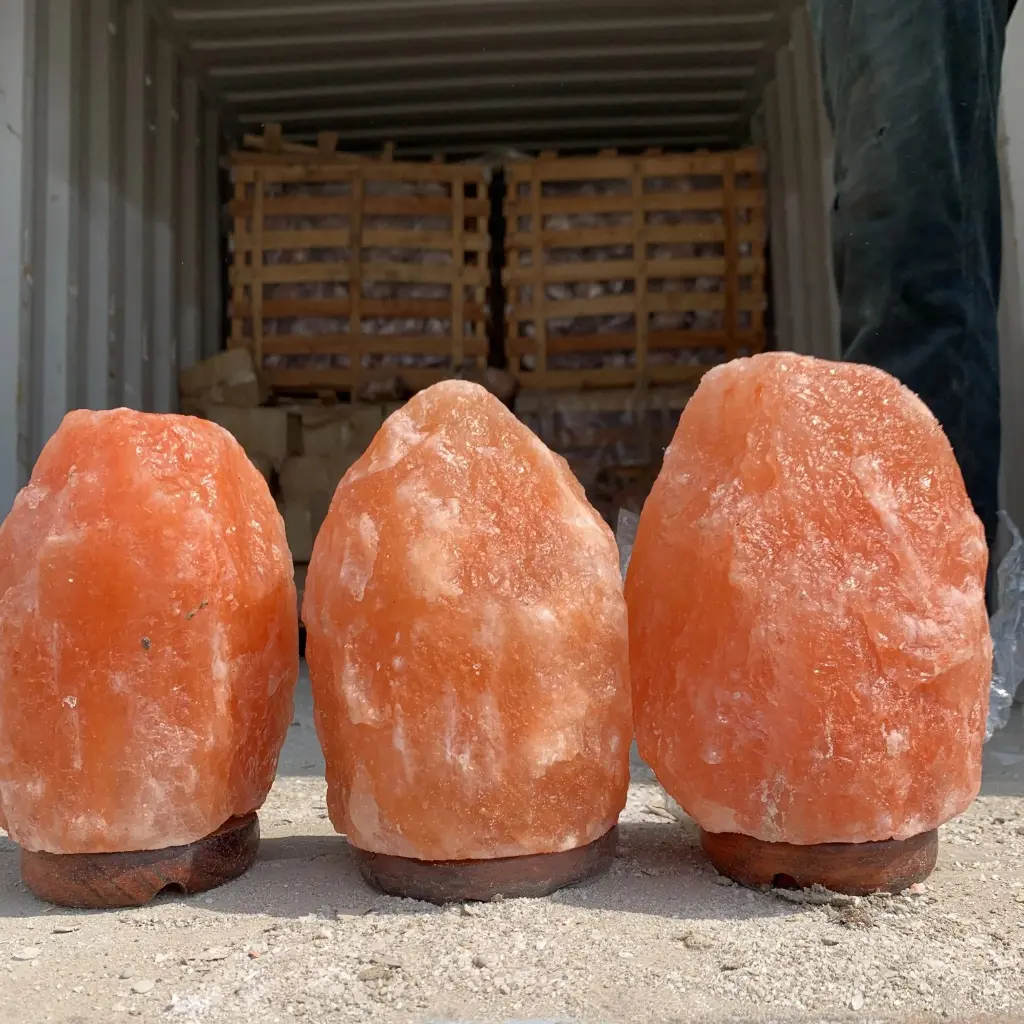 Three authentic, high-density Himalayan salt lamps with natural geological variations and amber glow, ready for B2B export shipment.