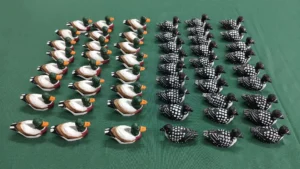Bulk production of handcrafted wooden duck decoys in a factory showroom for international wholesale export.