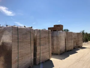 Factory outdoor storage of palletized pink Himalayan salt blocks with protective wrapping ready for wholesale distribution and export