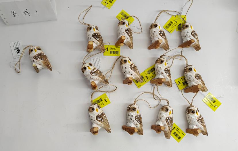 Hand-carved wood owl and eagle sculptures displayed in a premium gift shop.