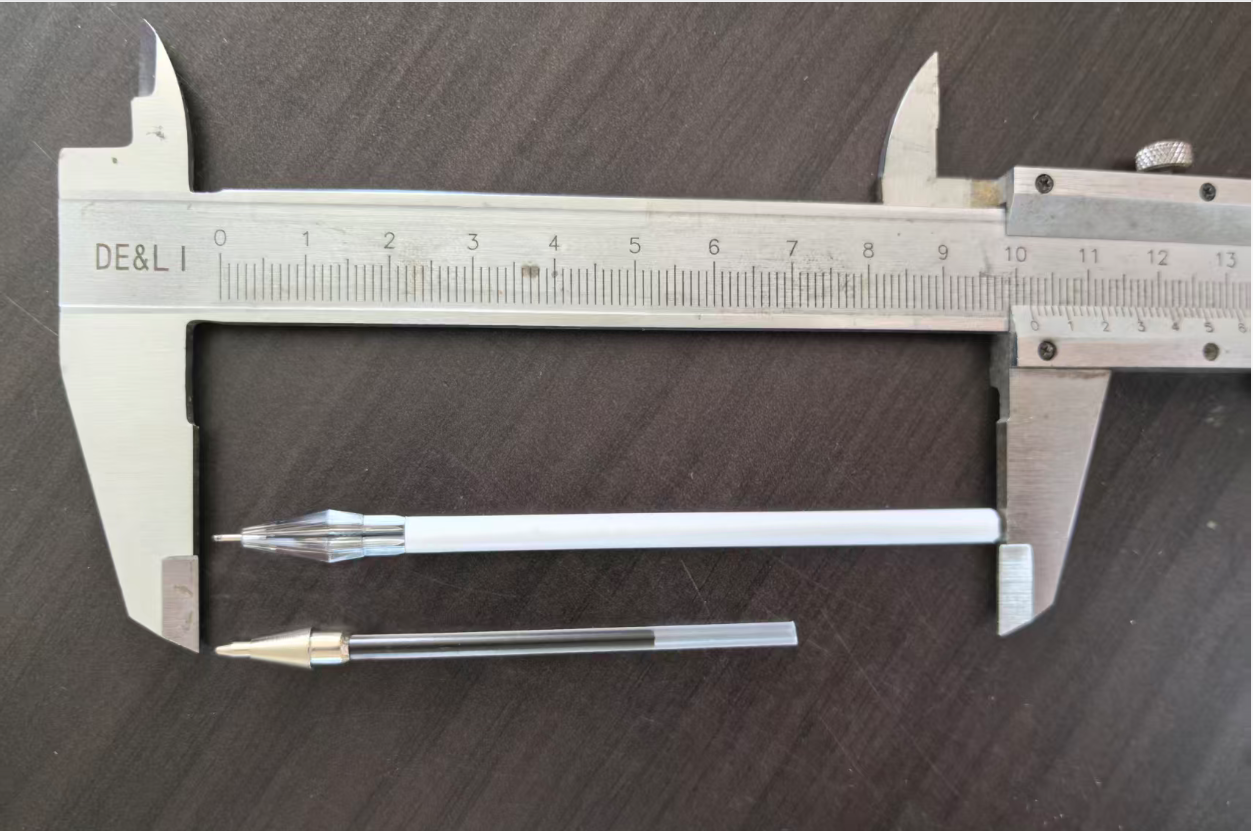 Two wooden pen refill types measured with caliper: top is a 10cm diamond-shaped black carbon refill with protective cap, bottom is a 7cm standard ballpoint refill available in blue and black ink