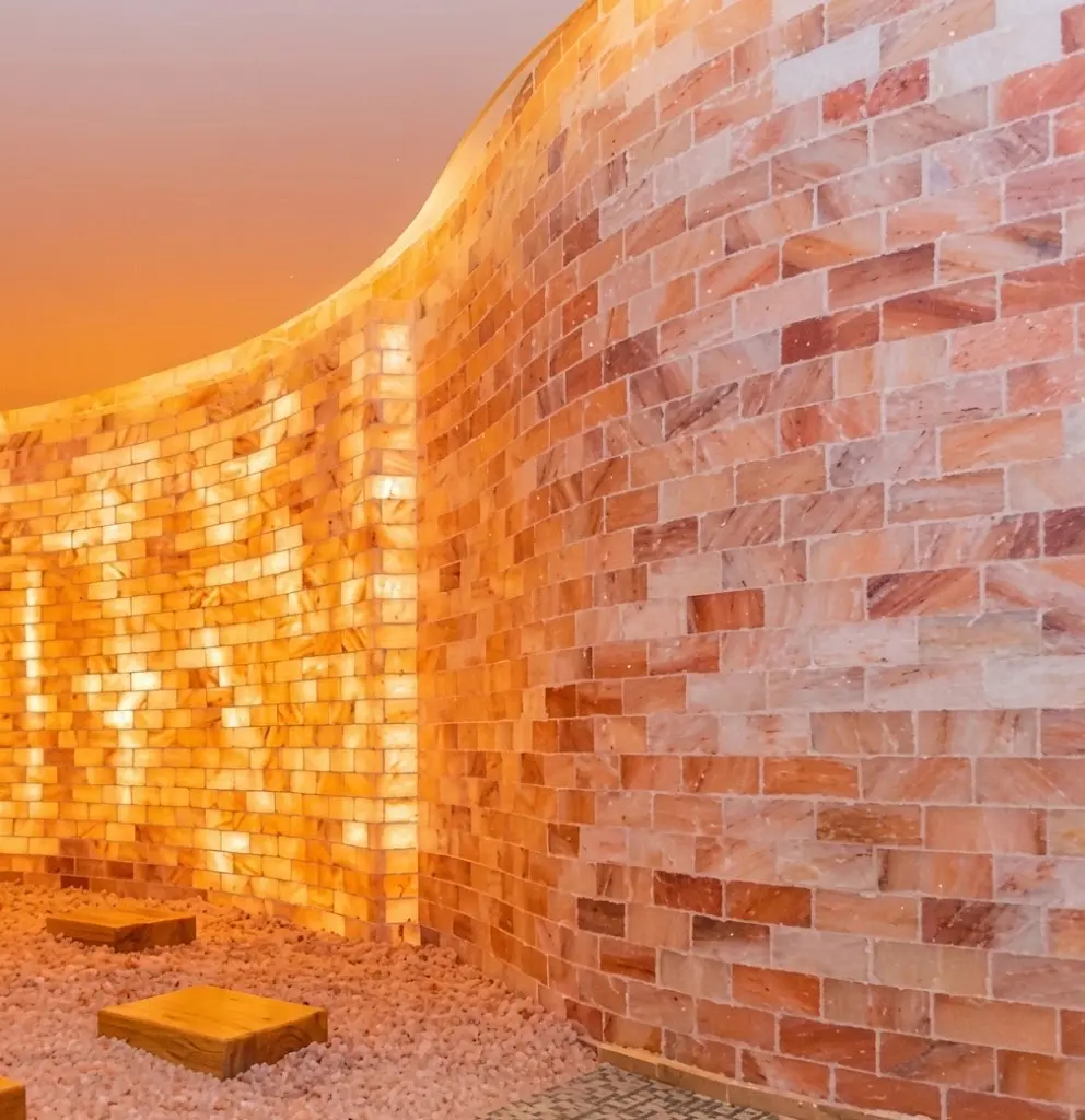Curved illuminated Himalayan salt brick wall in a halotherapy room