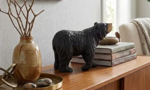 Hand-carved wooden black bear statement piece styled on a modern entryway console table with books and home decor.