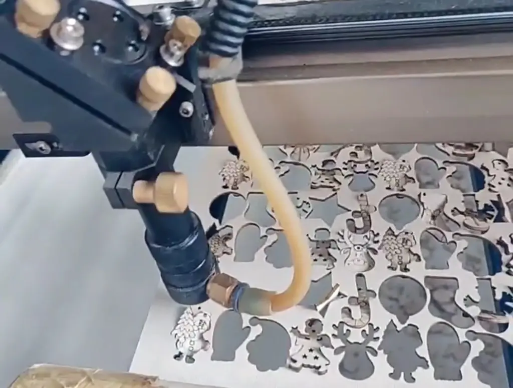 Laser cutting machine producing high-volume flat wooden Christmas ornaments for engraved client gift programs