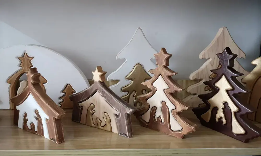 Handcrafted wooden Christmas Nativity sets featuring layered carved holy family figures in various wooden finishes.